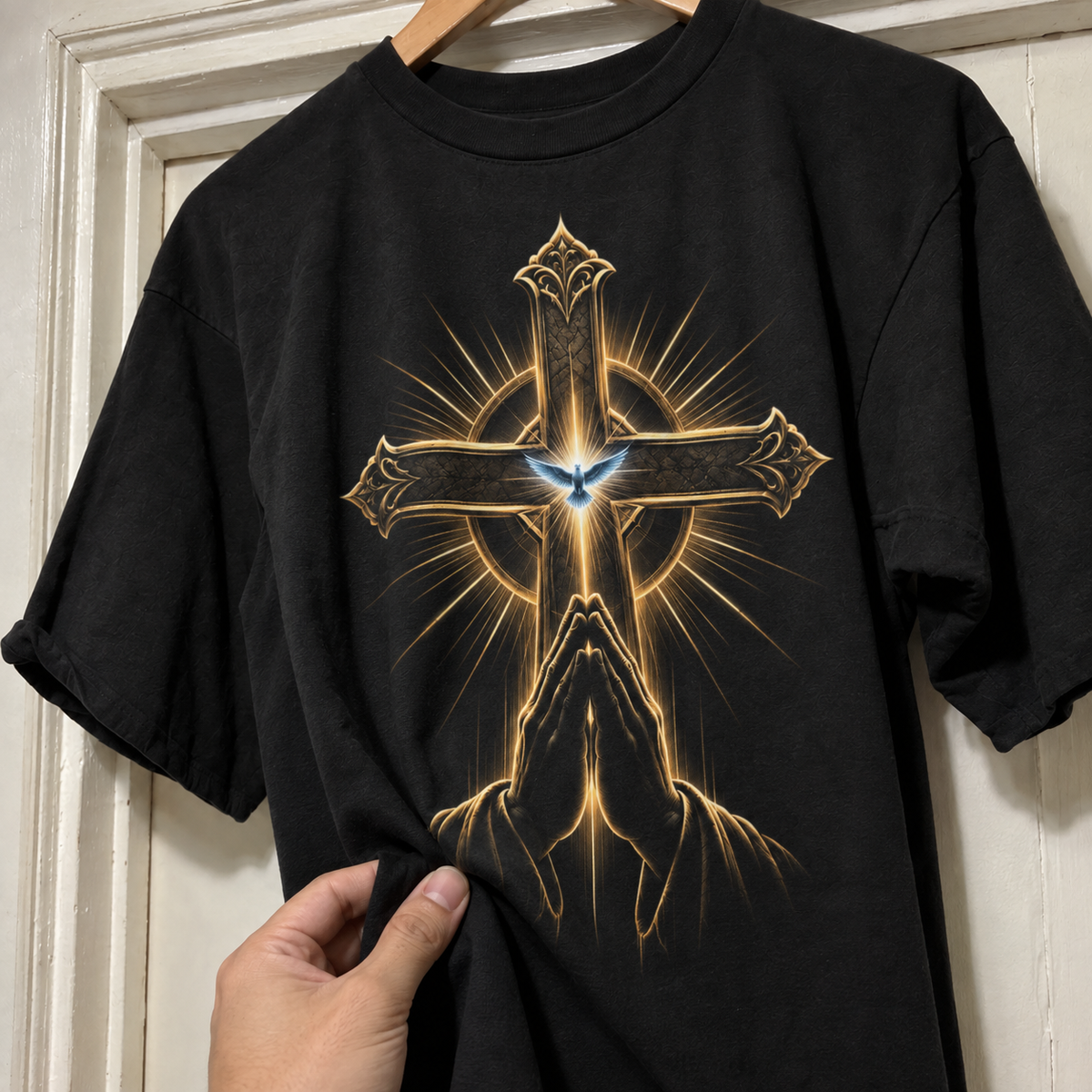 Detalhe do toque da camiseta Cruz Dourada e Mãos em Oração