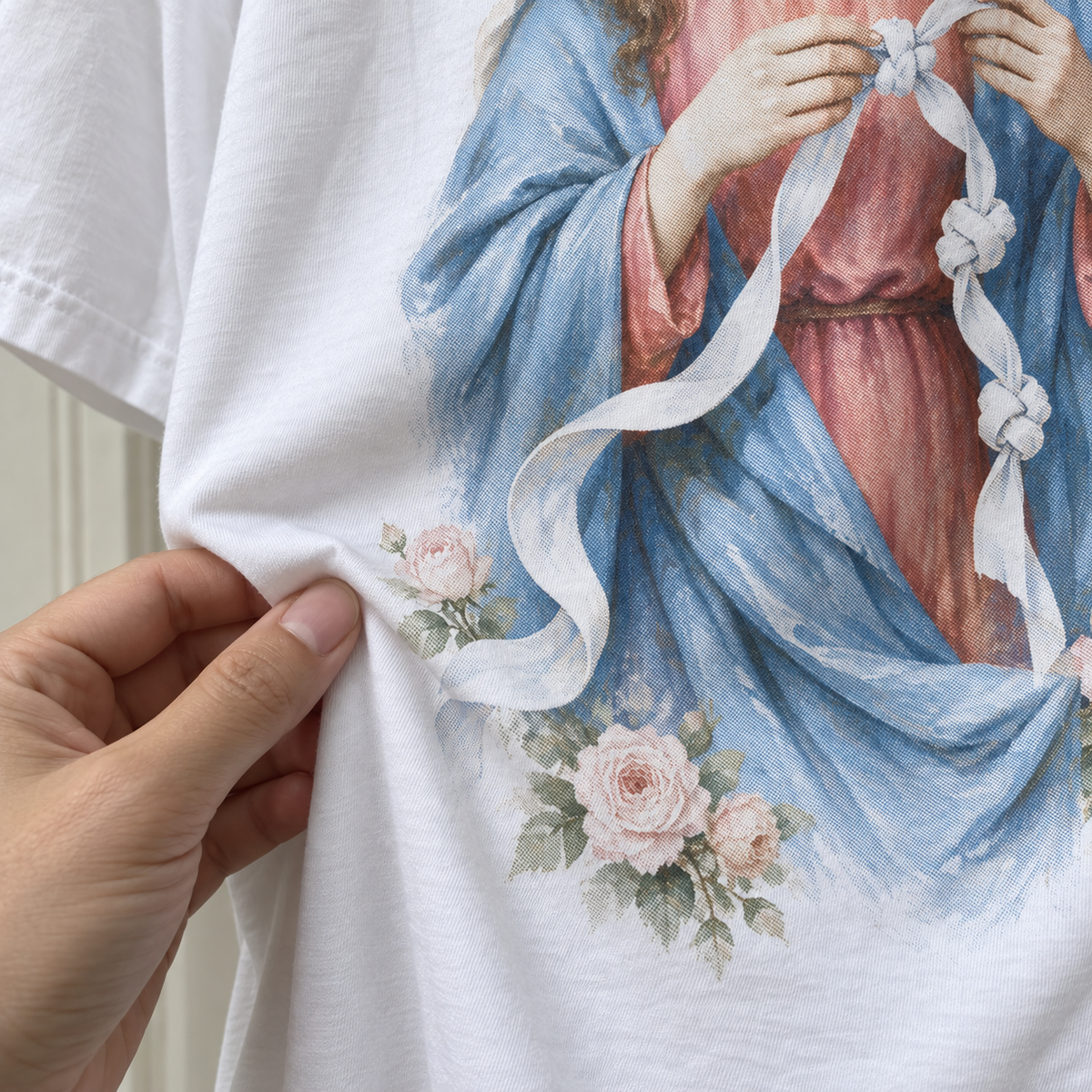 Tecido da camiseta branca Maria Desatadora dos Nós em movimento