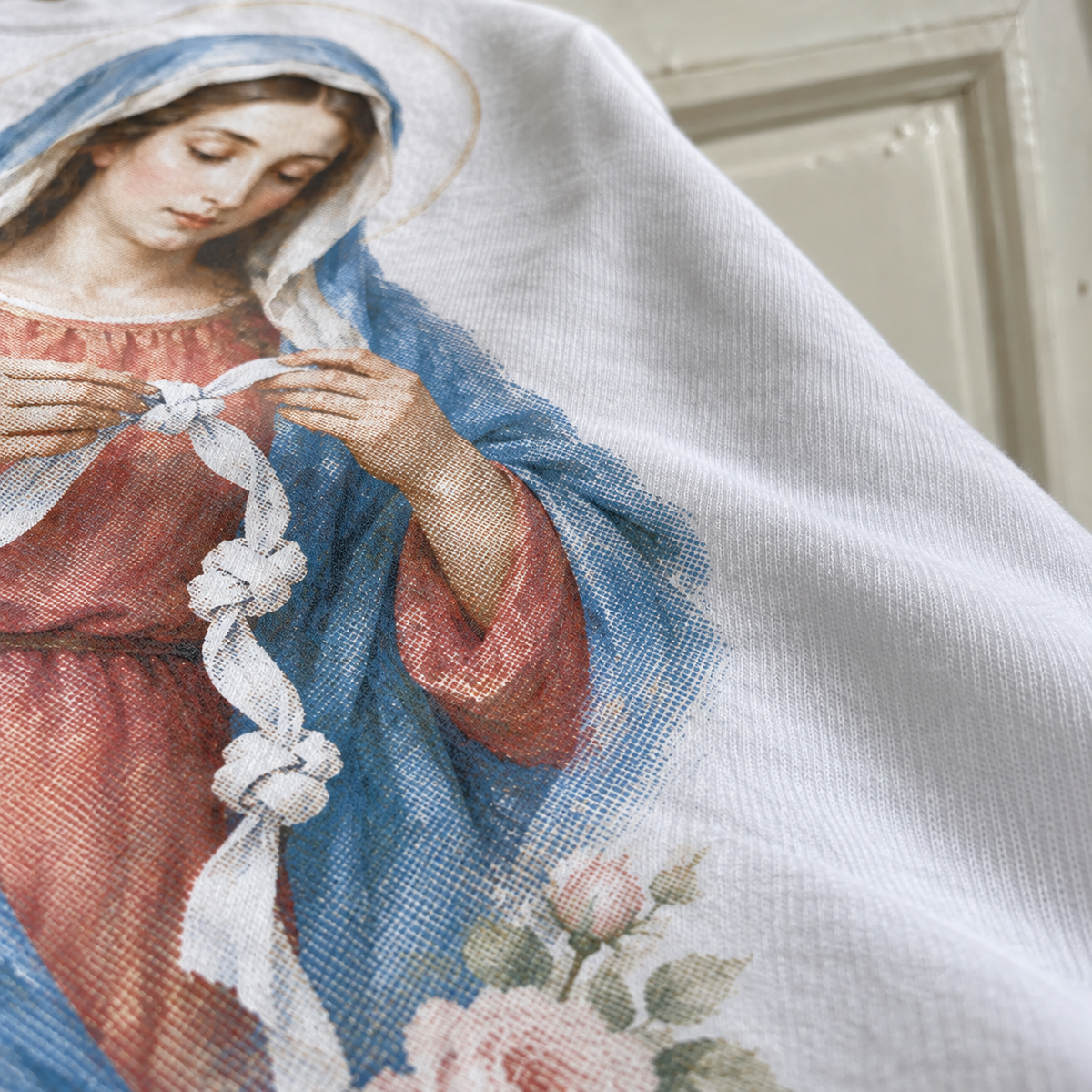 Textura da camiseta branca com a estampa Maria Desatadora dos Nós